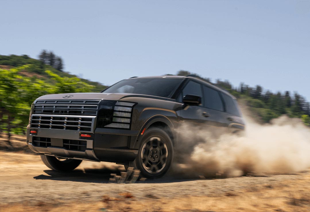 Hyundai Palisade XRT PRO en conduite hors route, soulevant de la poussière.