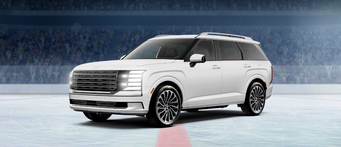Hyundai Palisade hybride édition limitée NHL, en blanc crème, présenté dans une aréna de hockey.
